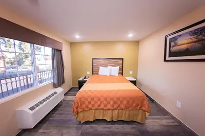 a bedroom with a bed and a large window at GAREY MOTEL in Pomona