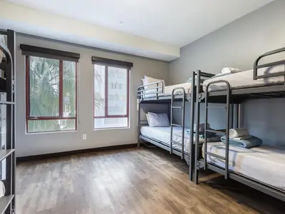 a room with three bunk beds and two windows at HI Los Angeles Santa Monica Hostel in Los Angeles