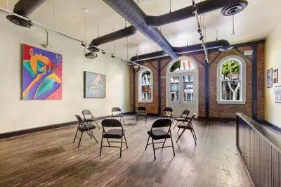 a room with chairs and a large painting on the wall at HI Los Angeles Santa Monica Hostel in Los Angeles