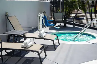 a pool with a slide and two chairs and a playground at Quality Inn Burbank Airport in Burbank