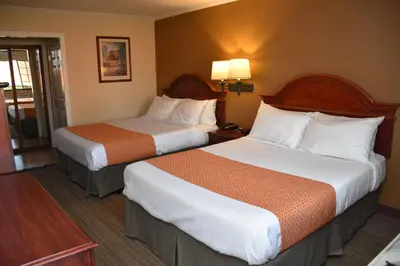 a hotel room with two beds in a room at Dynasty Suites Redlands in Redlands