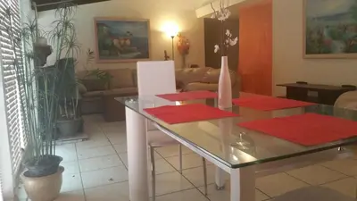 a living room with a glass table with red mats at Woodland Hills BEST Priced Room in Woodland Hills