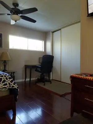 a bedroom with a desk and a chair and a ceiling fan at Woodland Hills BEST Priced Room in Woodland Hills