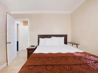 a bedroom with a large bed with a wooden headboard at Nite Inn at Universal City - Walking Distance to Universal Studios Hollywood in Los Angeles