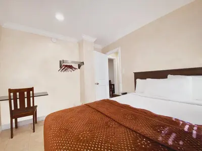 a bedroom with a large bed and a chair at Nite Inn at Universal City - Walking Distance to Universal Studios Hollywood in Los Angeles