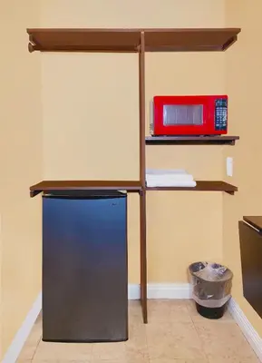a black refrigerator in a room with a shelf at El Patio Inn - Near Universal Studios Hollywood in Los Angeles