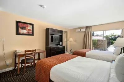 a hotel room with two beds and a desk at The Lemon Tree Hotel in Anaheim