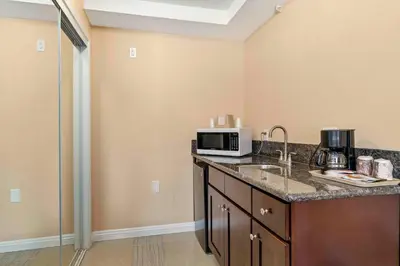 a kitchen with a sink and a microwave at The Lemon Tree Hotel in Anaheim
