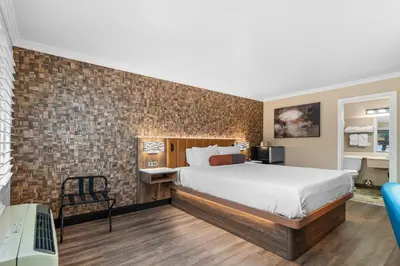a bedroom with a bed and a brick wall at Santa Clarita Motel - Near six Flags Magic Mountain - Valencia in Santa Clarita