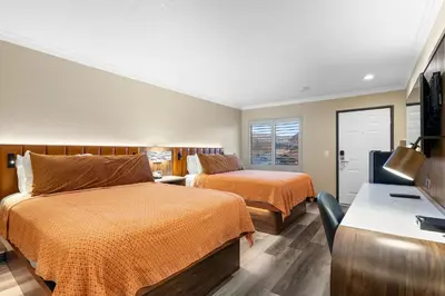 a hotel room with two beds and a desk at Santa Clarita Motel - Near six Flags Magic Mountain - Valencia in Santa Clarita