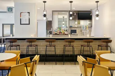 a bar in a restaurant with tables and chairs at Courtyard Culver City Los Angeles in Los Angeles