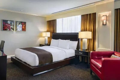 a hotel room with a bed and a red chair at Doubletree by Hilton Los Angeles Downtown in Los Angeles