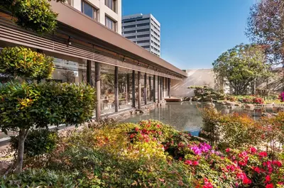 a garden in front of a building with flowers at Doubletree by Hilton Los Angeles Downtown in Los Angeles