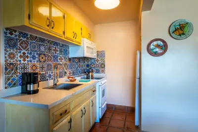 a kitchen with a sink and a refrigerator at Hotel Pepper Tree Boutique Kitchen Studios - Anaheim in Anaheim