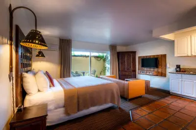 a hotel room with a bed and a kitchen at Hotel Pepper Tree Boutique Kitchen Studios - Anaheim in Anaheim