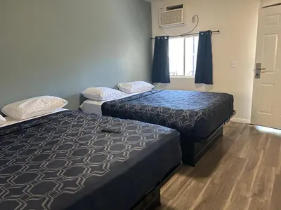two beds sitting in a room with a window at Budget Inn Hollywood in Los Angeles