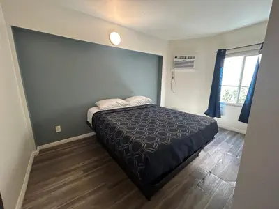 a bedroom with a bed and a large window at Budget Inn Hollywood in Los Angeles
