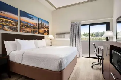 a hotel room with a bed and a television at Baymont by Wyndham Monterey Park in Monterey Park