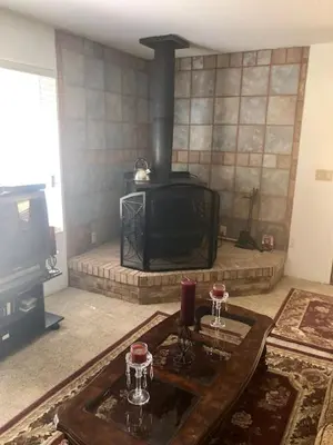a living room with a fireplace and a table with glasses at Sequoia National Forest CabinM in Panorama Heights