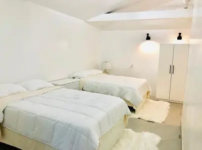 two beds in a room with white walls at Culver City Hostel in Los Angeles