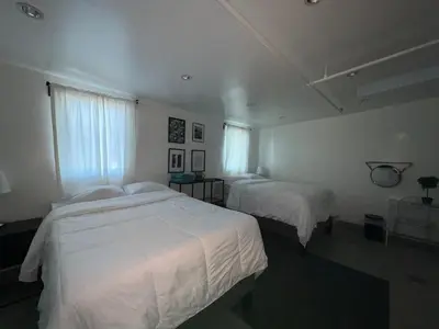 a bedroom with two beds and two windows at Culver City Hostel in Los Angeles