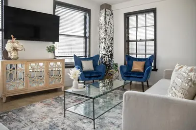a living room with a tv and blue chairs at Angel City 1 bedroom Apartment in Los Angeles