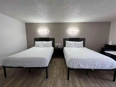 two beds in a room with white sheets at Motel 6-Orange, CA - Anaheim in Anaheim