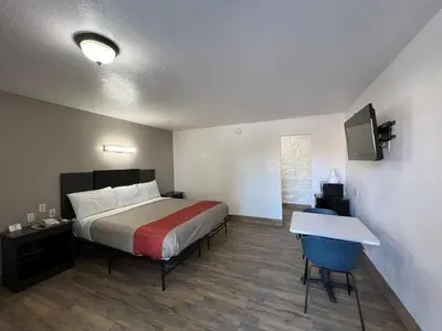 a bedroom with a bed and a table and a desk at Motel 6-Orange, CA - Anaheim in Anaheim