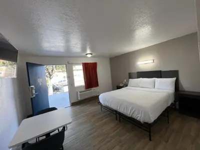 a bedroom with a bed and a desk and a table at Motel 6-Orange, CA - Anaheim in Anaheim