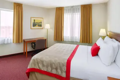 a hotel room with a large bed and a desk at Ramada by Wyndham Hawthorne/LAX in Hawthorne