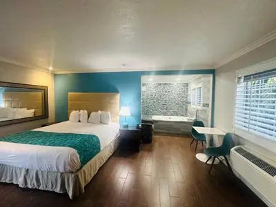 a hotel room with a large bed and a bathroom at Casa Blanca Hotel - Orange in Orange