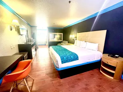 a hotel room with a bed and a desk and chair at Casa Blanca Hotel - Orange in Orange
