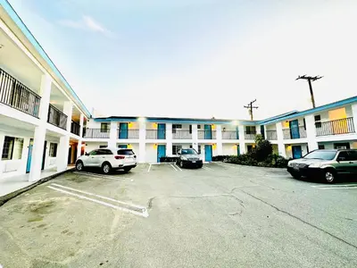 a parking lot in front of a large building at Casa Blanca Hotel - Orange in Orange