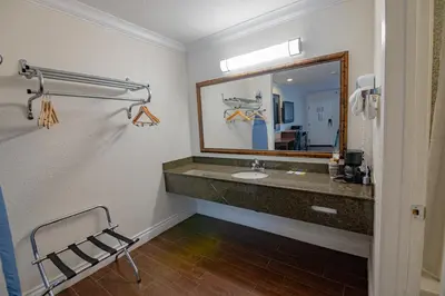 a bathroom with a sink and a mirror at Hospitality Inn in San Bernardino