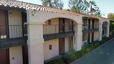 an apartment building with a balcony and a street at Hospitality Inn in San Bernardino