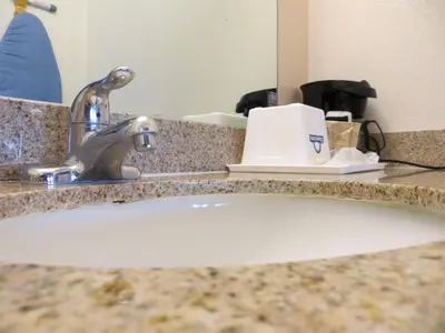 a bathroom counter with a sink with a faucet at Cabana Inn & Suites in Long Beach