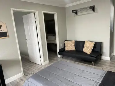 a living room with a black couch and a mirror at Cabana Inn & Suites in Long Beach