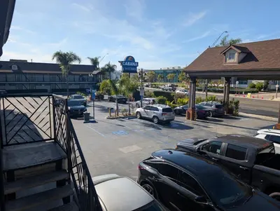 a parking lot with cars parked in front of a dealership at Cabana Inn & Suites in Long Beach