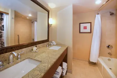 a bathroom with a sink and a tub and a mirror at Lake Arrowhead Resort & Spa in Lake Arrowhead