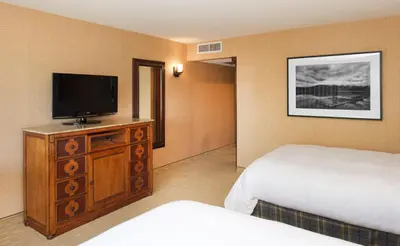 a hotel room with a bed and a flat screen tv at Lake Arrowhead Resort & Spa in Lake Arrowhead