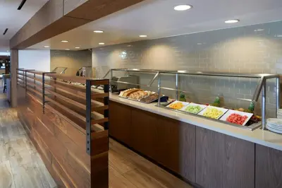 a buffet line in a restaurant with some food at Four Points by Sheraton Los Angeles Westside in Los Angeles