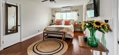 a bedroom with a bed and a vase of flowers on a table at Studio Mins to LAX , Venice Beach & Sony Studios CC B in Los Angeles