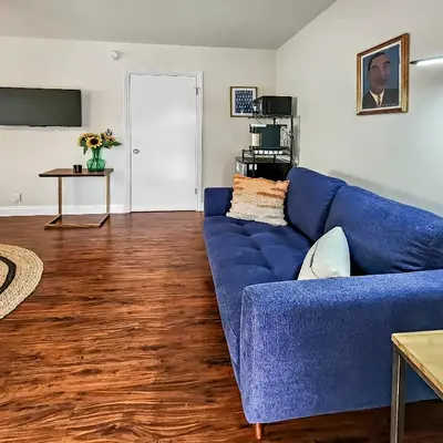 a blue couch in a living room with a wooden floor at Studio Mins to LAX , Venice Beach & Sony Studios CC B in Los Angeles