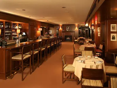 a restaurant with tables and chairs and a bar at Sunset Tower Hotel in Los Angeles