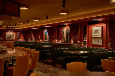 a restaurant with leather chairs and tables and red walls at The Georgian Hotel in Los Angeles