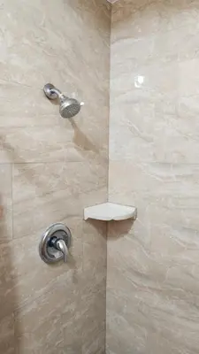 a shower with a shower head in a bathroom at Royal Century Hotel at LAX in Inglewood