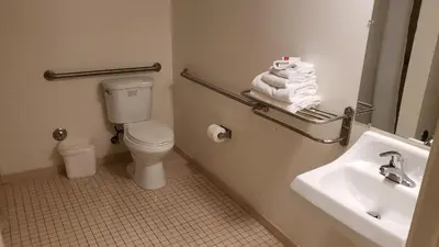 a bathroom with a toilet and a sink and a mirror at Royal Century Hotel at LAX in Inglewood