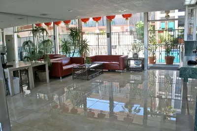 a lobby with couches and plants in a building at Royal Century Hotel at LAX in Inglewood