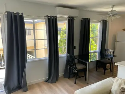 a dining room with black curtains and a table at Renovateed Two-Bedroom Apartment in Santa Monica in Los Angeles