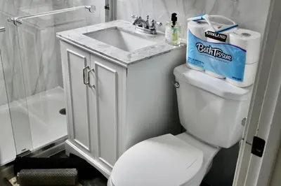 a bathroom with a white toilet and a sink at Chic Apartment in Los Angeles